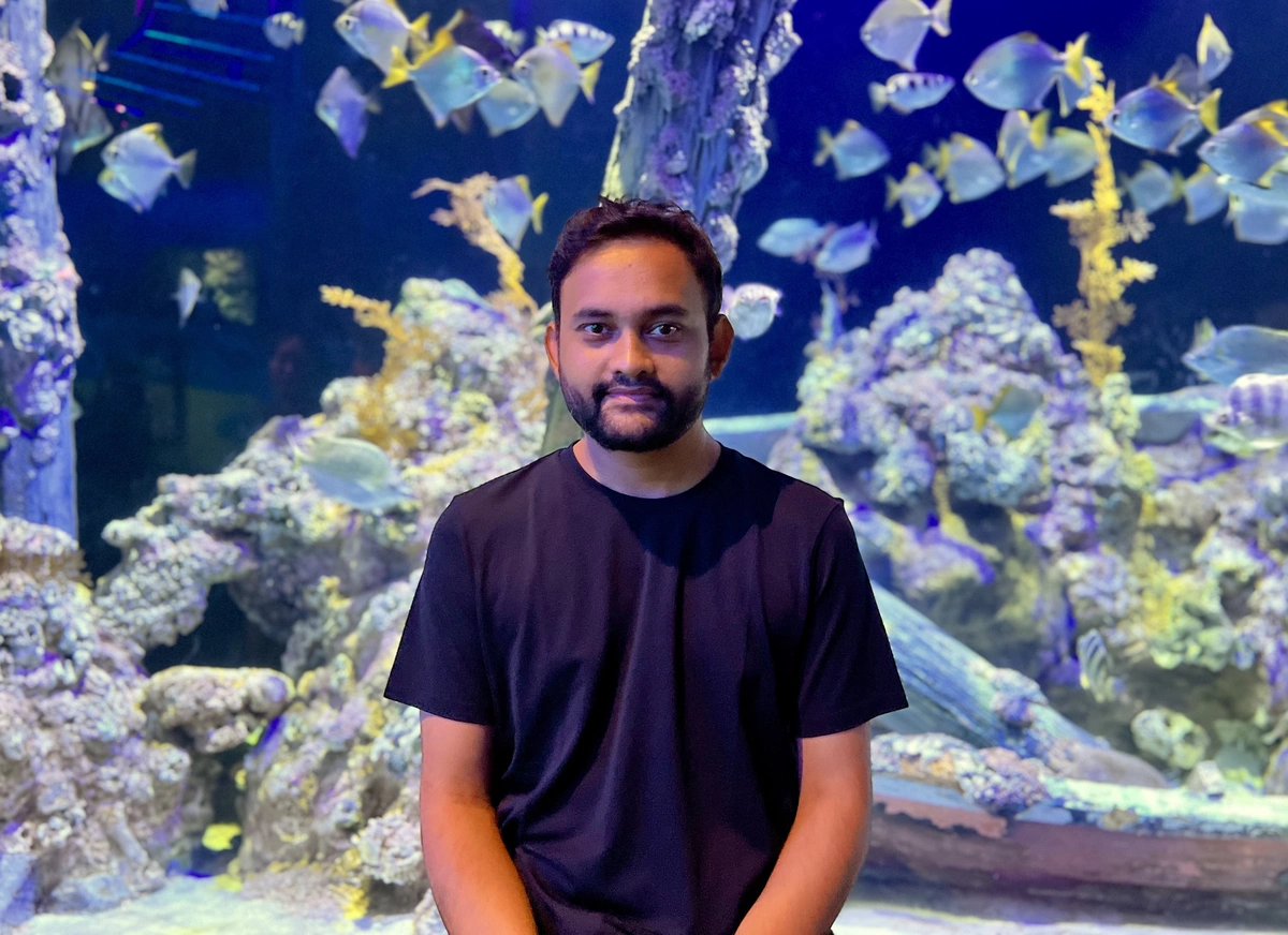 Vipul Gupta standing in front of an aquarium.